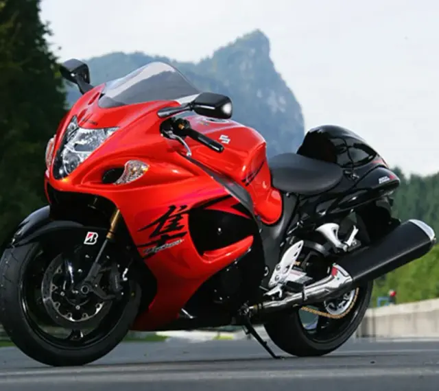 Czerwony motocykl Suzuki Hayabusa na drodze, z widokiem na góry. Poznaj jego suzuki hayabusa dane techniczne.