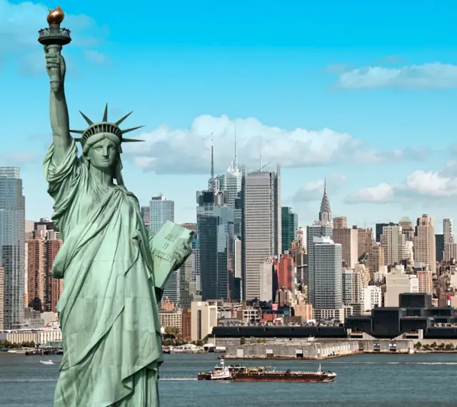 Statua Wolności wita na wycieczce do USA. W tle panorama Nowego Jorku z drapaczami chmur.