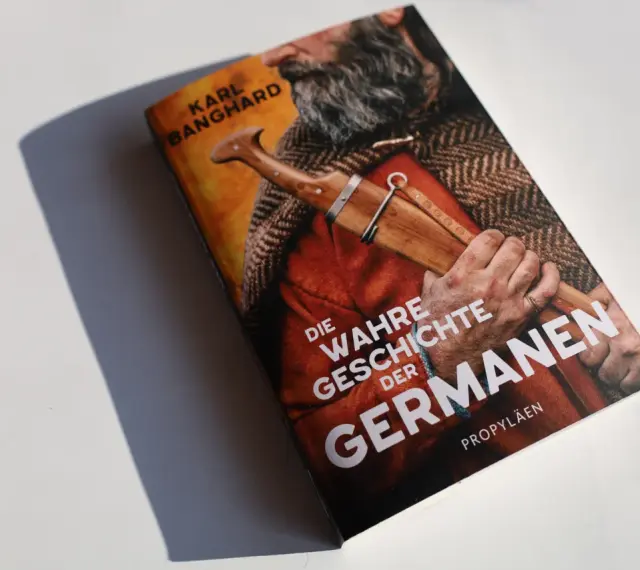 Buchcover "Die wahre Geschichte der Germanen" von Karl Banghard. Ein Mann mit Bart und Dolch im Gewand.