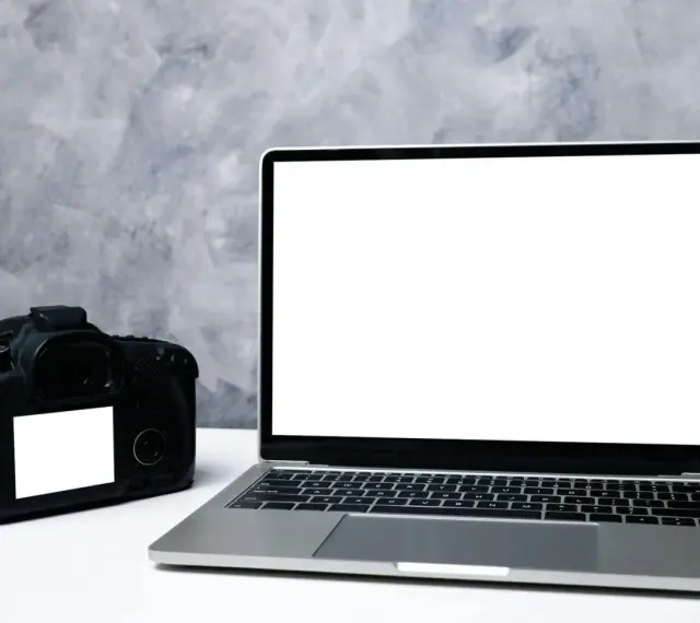 Aparat fotograficzny i laptop z pustym ekranem. Idealne do nauki, jak zgrać zdjęcia z aparatu na komputer.