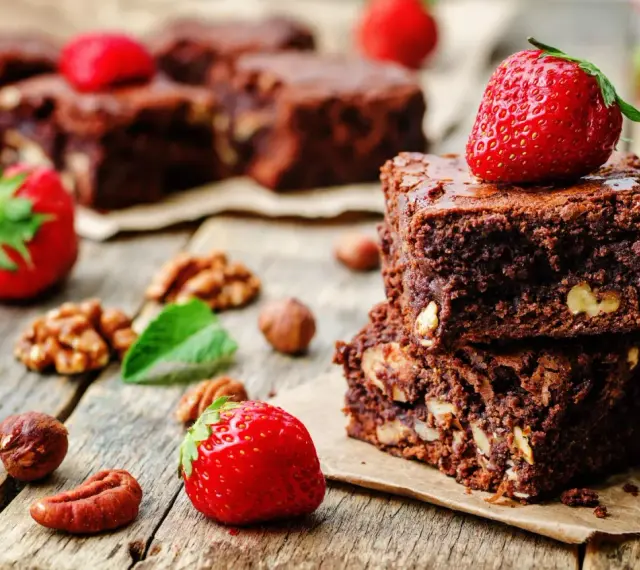 Czekoladowe brownie z orzechami i truskawkami. Pyszna przekąska, której brownie kcal nie zrujnuje diety.
