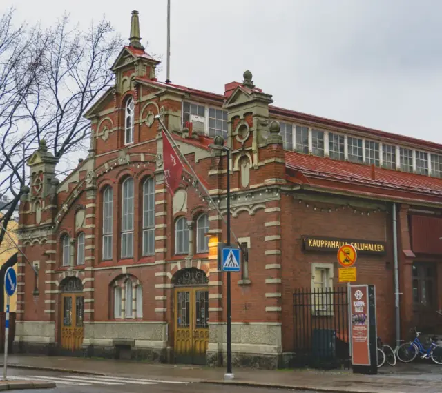 Targowisko Kauppahalli w Turku, najstarszym mieście w Finlandii, z charakterystyczną ceglaną fasadą i czerwonym dachem.