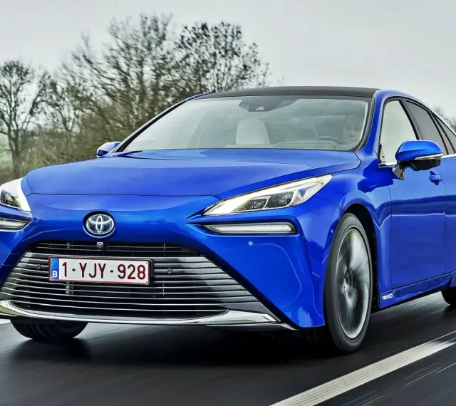 Niebieska Toyota Mirai jedzie po drodze. Sprawdź aktualną toyota mirai cena i dowiedz się więcej o tym innowacyjnym samochodzie.