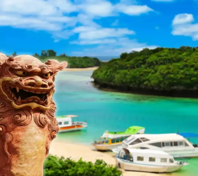 Kamienna lwica strzeże rajskiej plaży z łodziami na archipelagu z Okinawą.