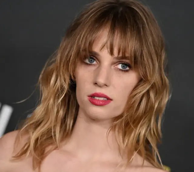 Maya Hawke, znana z filmów, seriali i programów, z burzą blond włosów i wyrazistymi ustami.