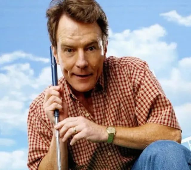Bryan Cranston w kratę, z kijem golfowym, przypomina postać z jego filmów i seriali.