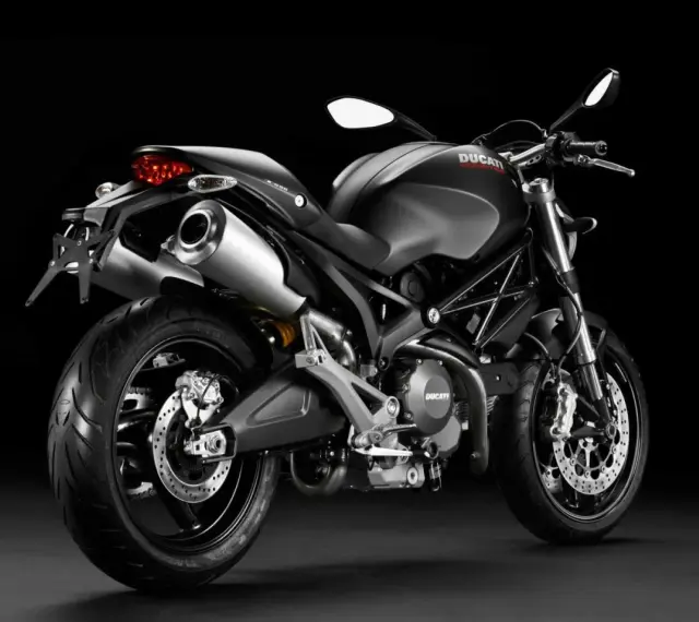 Czarny Ducati Monster 696 z podwójnym wydechem i sportowym wyglądem, gotowy do jazdy.