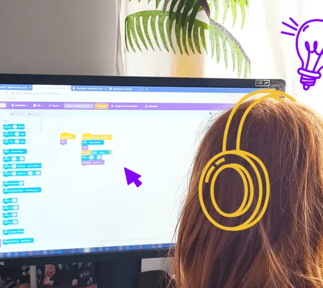 Dziewczynka w słuchawkach tworzy kod w Scratch po polsku, ucząc się programowania.