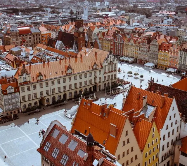Widok z góry na Rynek we Wrocławiu z kolorowymi kamienicami i ratuszem.