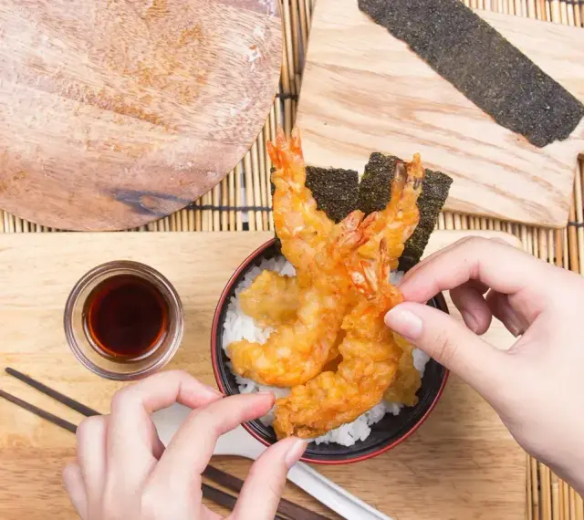 Chrupiące krewetki w cieście tempura na ryżu, gotowe do jedzenia. Idealny przepis na tempurę.