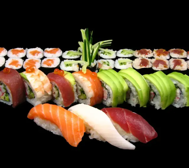 Różnorodne sushi: nigiri z łososiem, tuńczykiem i kalmarem, rolki z awokado, krewetką, tuńczykiem i krabem. Idealne na początek przygody, jak jeść sushi.
