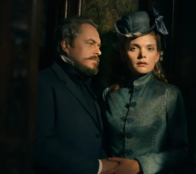 Para z epoki wiktoriańskiej, jak z serialu "Lalka" Netflix, w mrocznym wnętrzu.