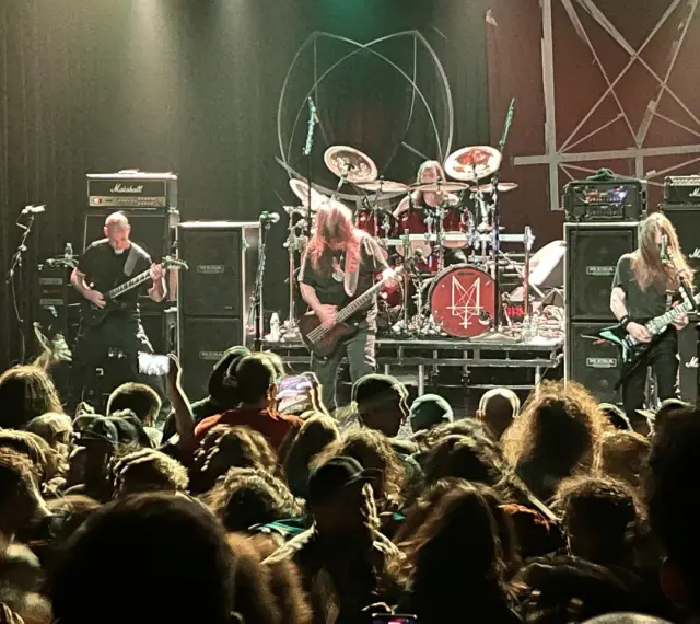 Concert de metal, musiciens sur scène, foule en délire. Le groupe semble prêt à envoyer du lourd, un vrai voyage ad patres pour les fans.