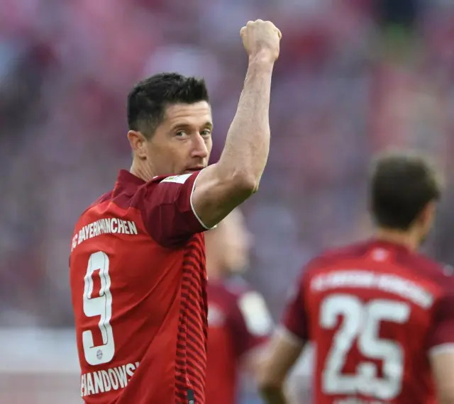 Piłkarz Robert Lewandowski w czerwonej koszulce z numerem 9 świętuje bramkę.