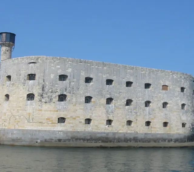 Fort Boyard, imponująca kamienna twierdza na wodzie, z licznymi oknami i wieżą.