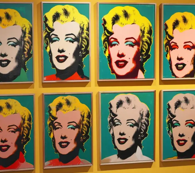 Osiem portretów Marilyn Monroe w stylu pop art Andy'ego Warhola, z różnymi kolorami tła i makijażu.