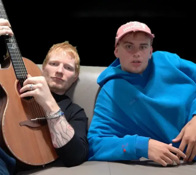 Ed Sheeran z gitarą i Yung Gravy w niebieskiej bluzie. "Azizam, co to znaczy?" - zastanawia się Yung Gravy, patrząc na tatuaże Eda.