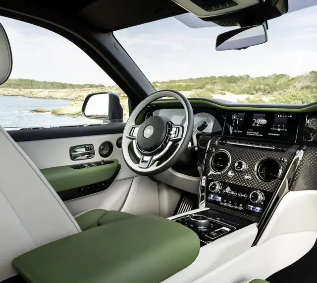 Wnętrze luksusowego Rolls-Royce SUV z zielonymi i białymi skórzanymi detalami, widok na morze.