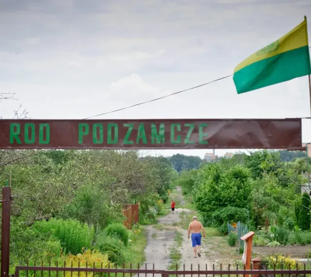 Kto stoi za kampanią "wolne działki ROD"? Czy protesty zablokują nowe przepisy? Wjazd do ROD Podzamcze, gdzie widać mężczyznę idącego ścieżką.