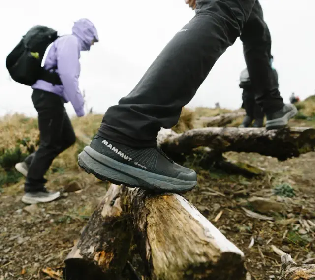 Jesienne buty w góry: turysta w butach Mammut Gore-Tex pokonuje przeszkody na szlaku.