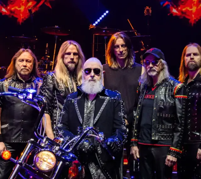 Judas Priest Polska: zespół w skórzanych kurtkach z ćwiekami, z motocyklem na scenie.