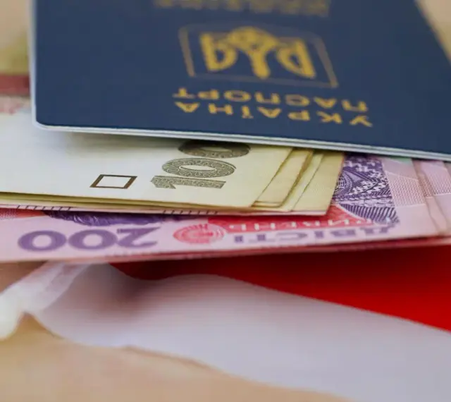 Ukraiński paszport z pieniędzmi, symbolizujący nadzieję na godną emeryturę dla Ukraińców w Polsce.