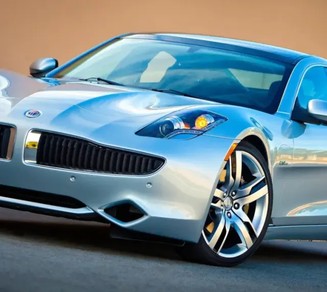 Srebrny Fisker Karma z eleganckimi liniami i sportowymi felgami, gotowy na podbój drogi.