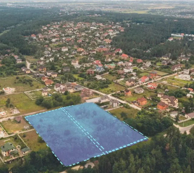 Działki bez planu ogólnego gminy będą niesprzedawalne od lipca 2026. Aerial view of suburban housing development with a highlighted plot of land.