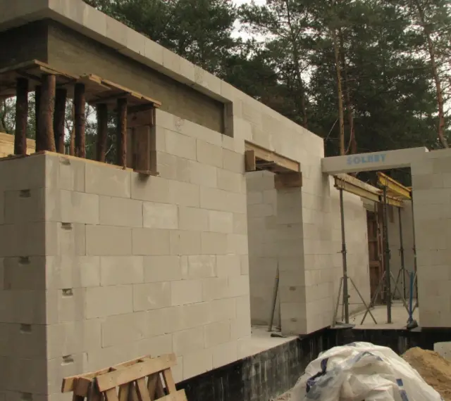 Budowa domu z bloczków betonowych. Widoczny maksymalny otwór bez nadproża, przygotowany do montażu okna lub drzwi.