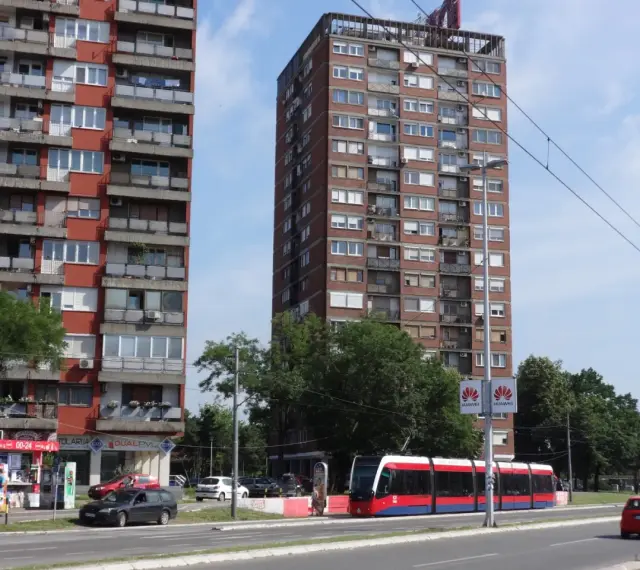 Wielopiętrowe budynki mieszkalne i nowoczesny tramwaj na ulicy. Czy w Belgradzie jest bezpiecznie? Wygląda na spokojne miasto.