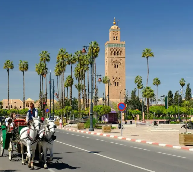 W Marrakeszu turyści mogą bezpiecznie podziwiać zabytki, takie jak minaret Koutoubia, podczas przejażdżki dorożką pośród palm.