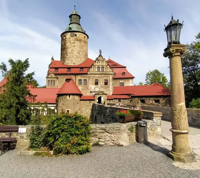 Zamek Czocha zaprasza na malowniczą trasę zwiedzania. Kamienne mury, wieże i czerwone dachy tworzą bajkowy krajobraz.