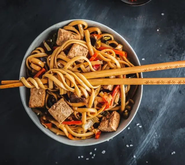 Miseczka z makaronem udon, tofu i warzywami, gotowa do jedzenia. Idealny makaron udon przepis na szybki obiad.