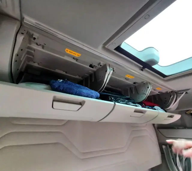 Schowek w kabinie Ford F-Max z niebieskim ręcznikiem i innymi przedmiotami.