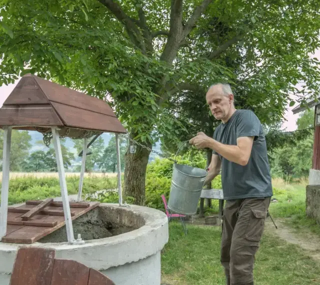 Mężczyzna czerpie wodę z **studni głębinowej**. Czy posiada **pozwolenie** na jej budowę?