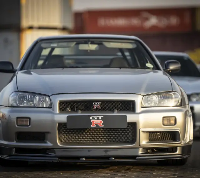 Srebrny Nissan GTR R34, ikona motoryzacji. Zastanawiasz się nad nissan gtr cena? Ten klasyk wciąż budzi emocje.