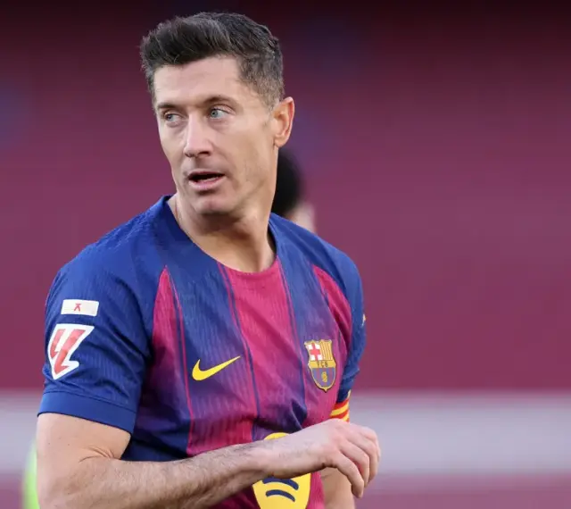 Robert Lewandowski w koszulce FC Barcelony, zastanawia się, kto jest najlepszym piłkarzem na świecie.