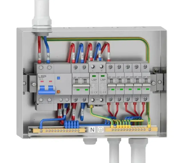 Wnętrze metalowej skrzynki elektrycznej z wyłącznikami i przewodami. Widać instalację rbk z bezpiecznikami i listwami zaciskowymi.