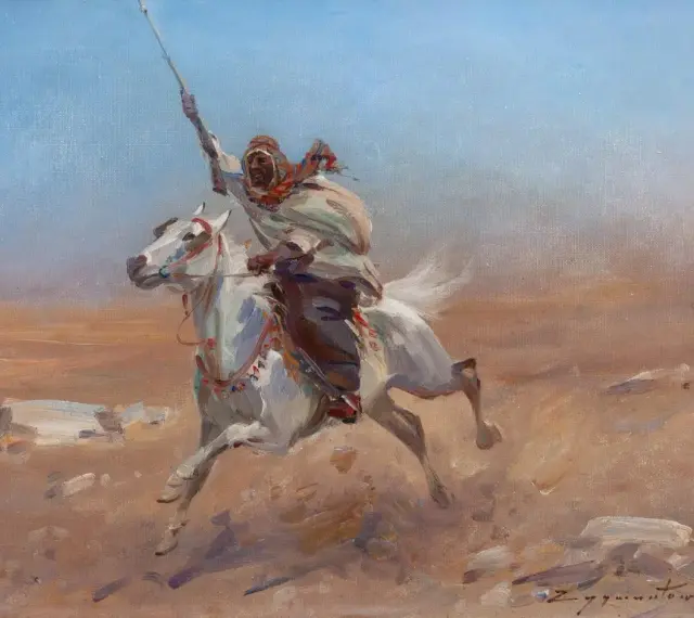 Biały koń galopuje przez pustynię, dosiada go wojownik w tradycyjnym stroju, z uniesioną włócznią. Obraz w stylu orientalizm.