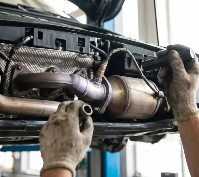 Mechanik sprawdza katalizator Nissana, podejrzewając błąd DTC P0420.