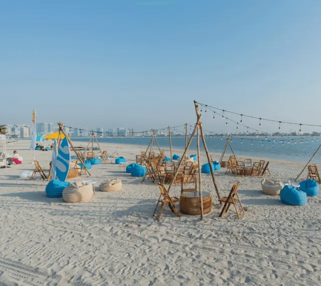 Plaża w Dubaju w lipcu: leżaki, stoliki i girlandy świateł tworzą letnią atmosferę.