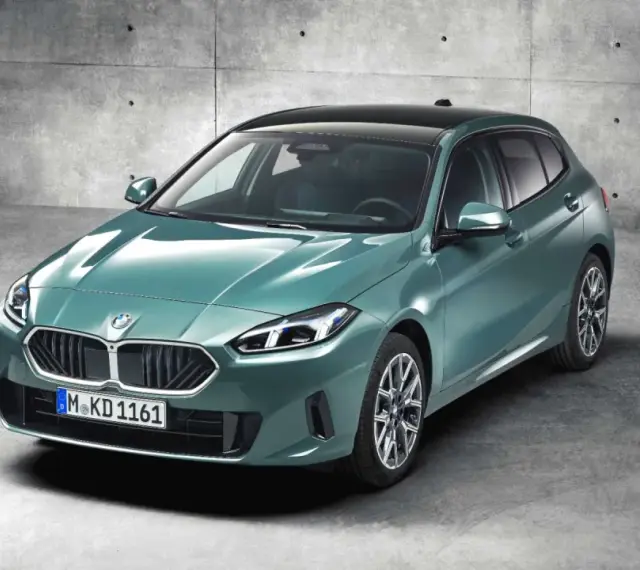 Nowy, zielony bmw hatchback z czarnym dachem, zaparkowany na betonowym podłożu.