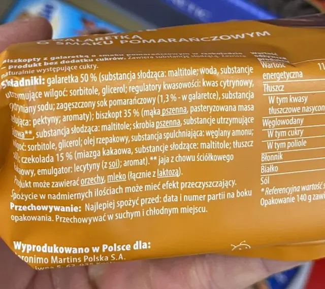 Pomarańczowe delicje kcal: biszkopt z galaretką i czekoladą. Na opakowaniu podano składniki i wartości odżywcze, w tym 275 kcal na 100g.