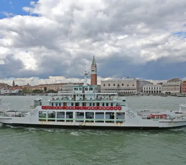 Traghetto ACTV che naviga sul Canal Grande, con lo sfondo di Venezia e il Palazzo Ducale.