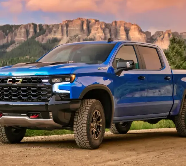 Niebieski Chevrolet pickup ZR2 na drodze w górach, gotowy na przygodę.