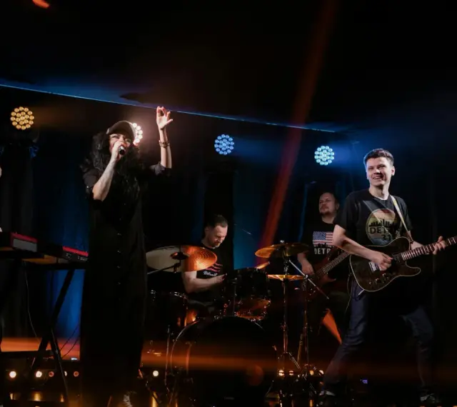 Zespół rockowy na scenie: wokalistka, gitarzysta, basista, perkusista i klawiszowiec. Koncert jak z listy zespoły rockowe zagraniczne alfabetycznie.