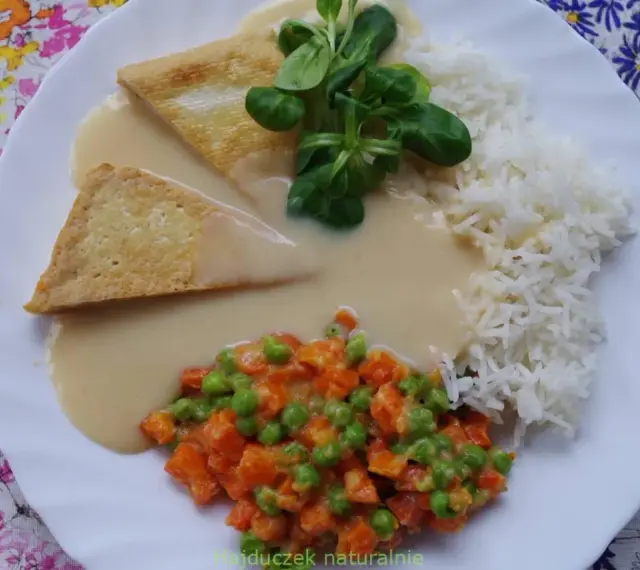 Trójkątne kawałki tofu w kremowym sosie madras, podane z ryżem i warzywami.