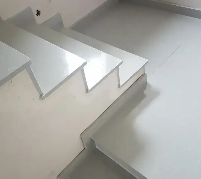 Nowoczesne schody z aglomarmuru w jasnym kolorze, idealne do minimalistycznych wnętrz.