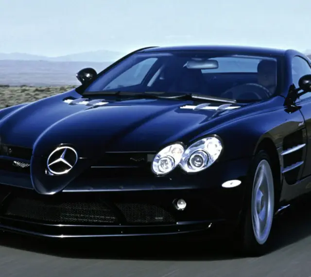 Czarny SLR McLaren pędzi po pustynnej drodze, jego sylwetka lśni w słońcu.
