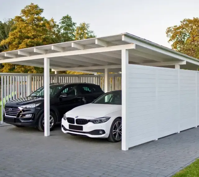 Nowoczesna budowa wiaty chroni dwa samochody: czarnego SUV-a i białe BMW. Elegancka konstrukcja z białymi panelami i dachem.